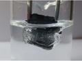 
Fot. 2. Uzyskany z grafenu materiał ma właściwości silnie hydrofobowe, czyli bardzo silnie odpycha od siebie cząsteczki wody. Na zdjęciu aerożel z grafenu jest wkładany do fiolki z wodą: widać że woda nie zwilża materiału, tworząc specyficzną „kieszeń” wokół aerożelu. Po upuszczeniu materiału na powierzchnię wody aerożel utrzymuje się na jej powierzchni, naukowcy zbadali również wagę aerożelu przed i po kontakcie z wodą. Brak różnicy wskazuje na to że areożel w ogóle nie absorbuje wody, co ma duże znaczenie w przypadku jego użycia do usuwania zanieczyszczeń ze środowiska wodnego.